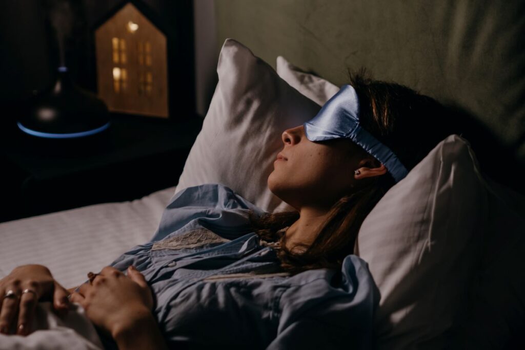 woman wearing sleep mask in bed